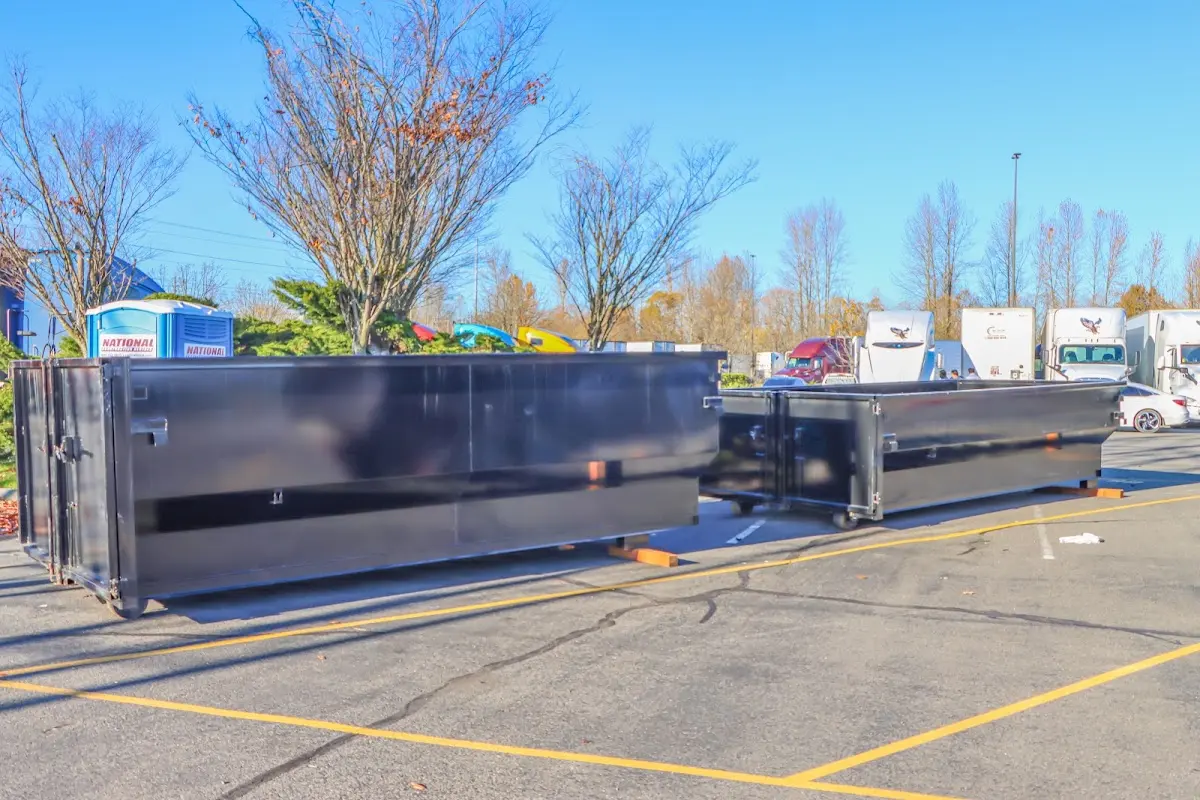 Professional dumpster rental service with roll-off container on residential driveway in Plaquemine
